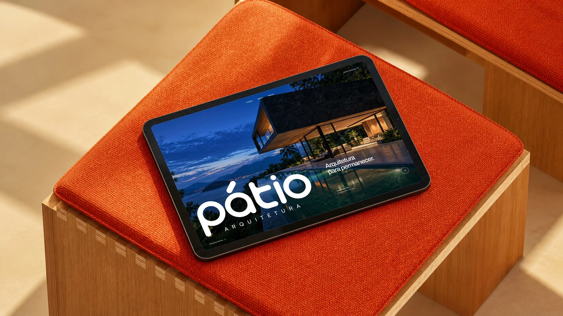 Pátio website on a tablet on an orange armchair