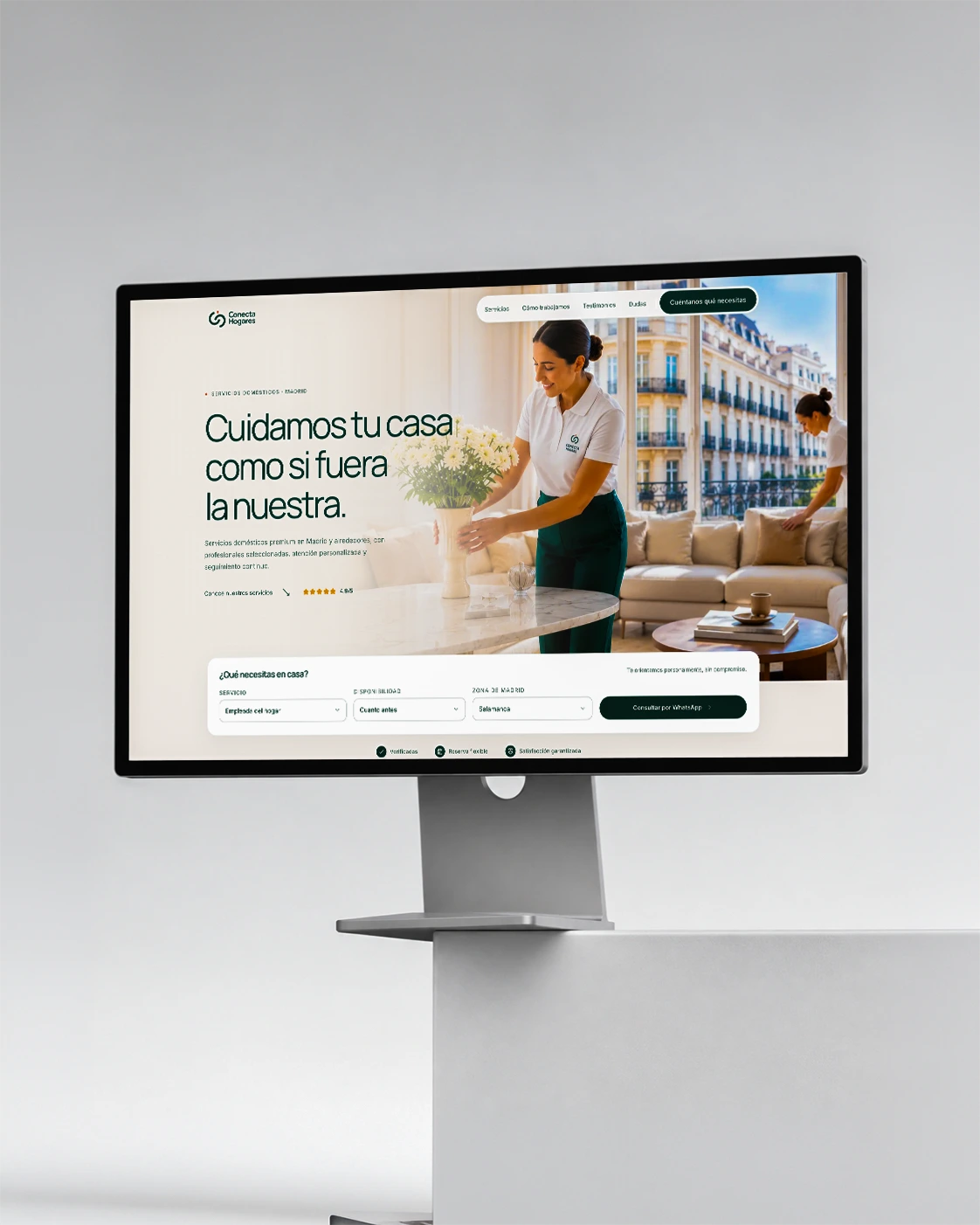 Conecta Hogares website on a monitor on a light-colored desk